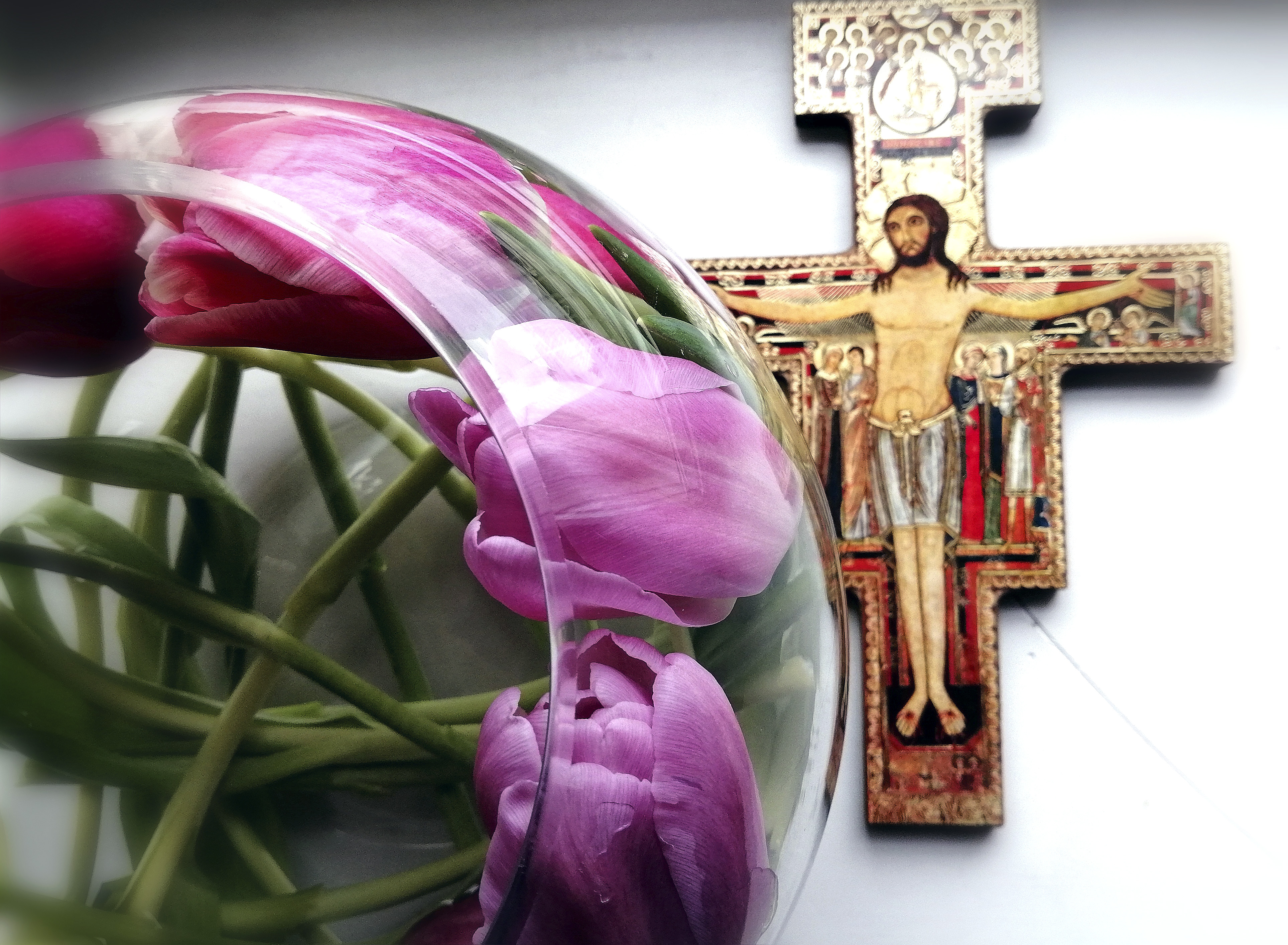 Malja, jossa tulppaaneja ja taustalla ikoni Jeesus ristillä.