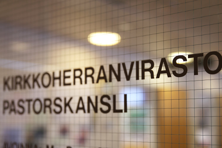 Kirkkoherranvirasto - teksti lasiovessa.