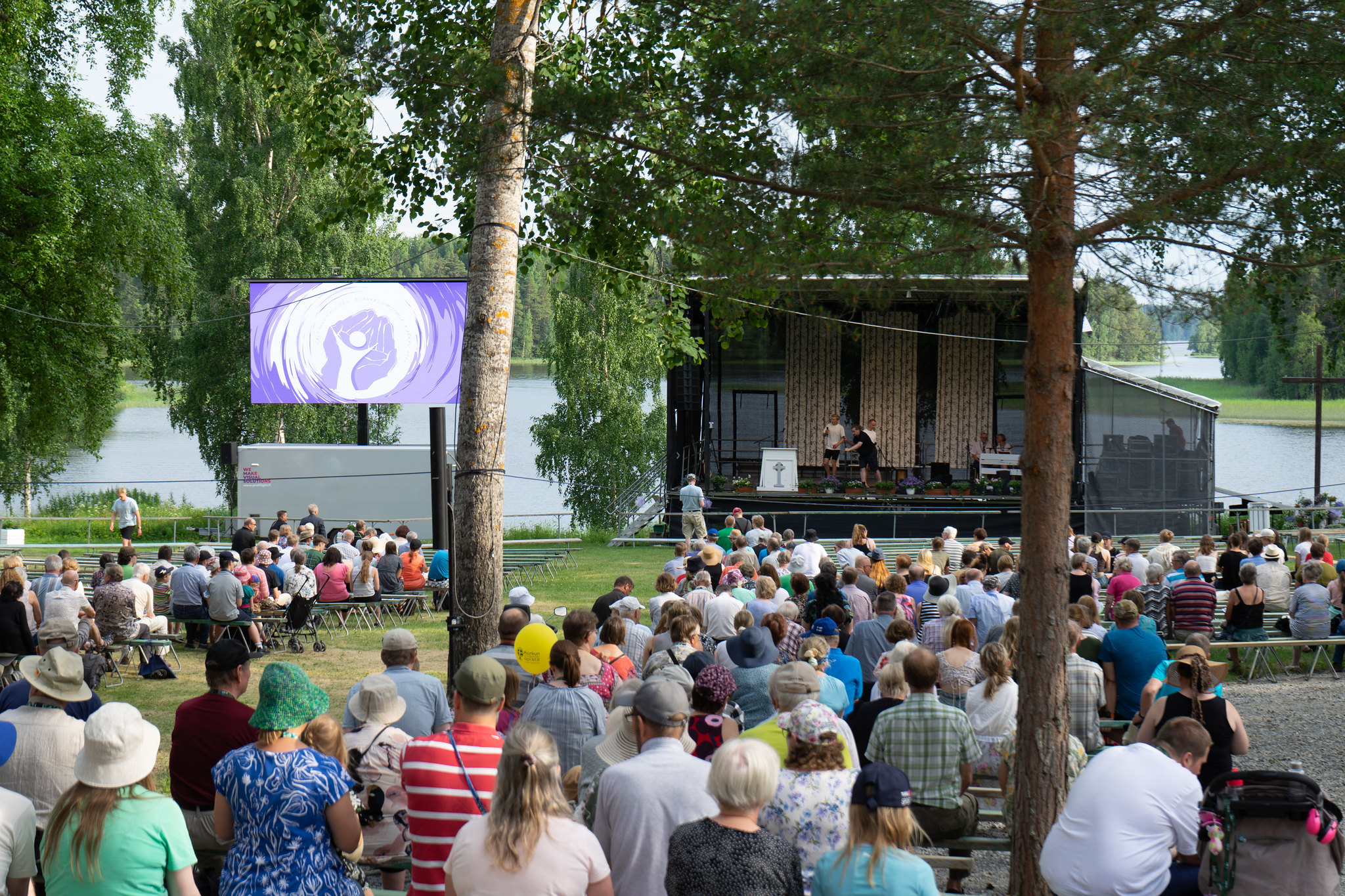 Runsas väkijoukko istuu penkeillä selin.