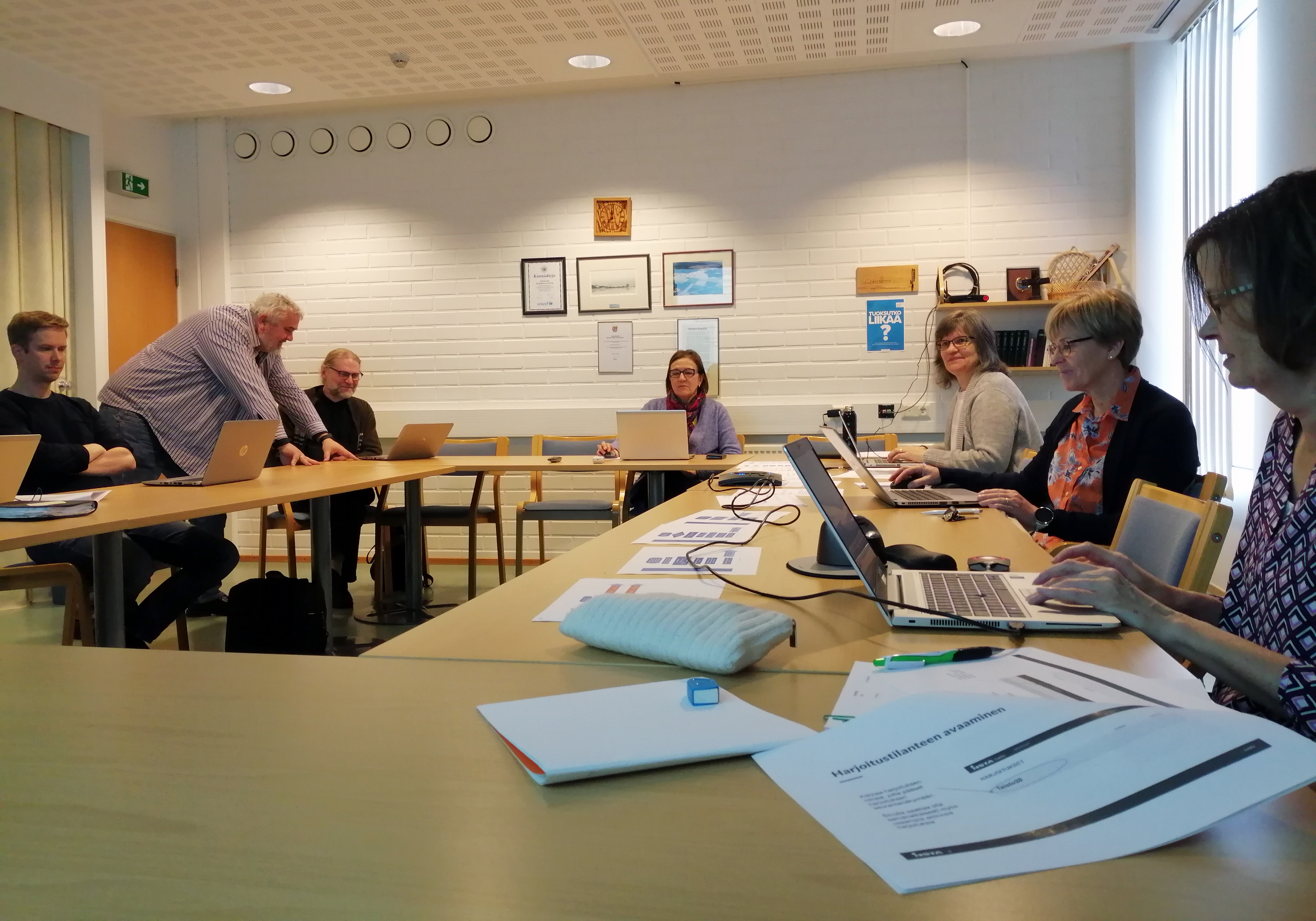 Ihmisiä kokouspöydän äärellä Jussintuvassa, Kokkolan seurakuntakeskuksen kokoustilassa.